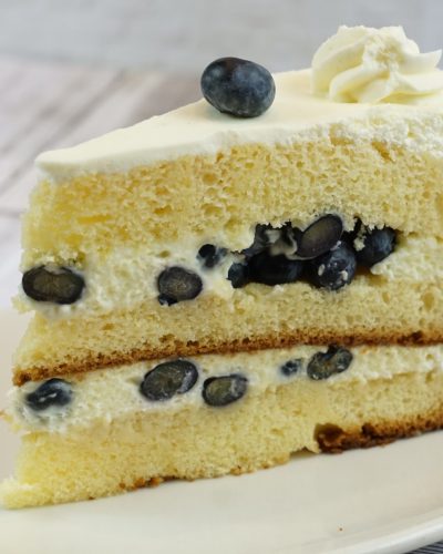 savor the classic flavor of a traditional lemon blueberry cake slice at Mia's Bakery.