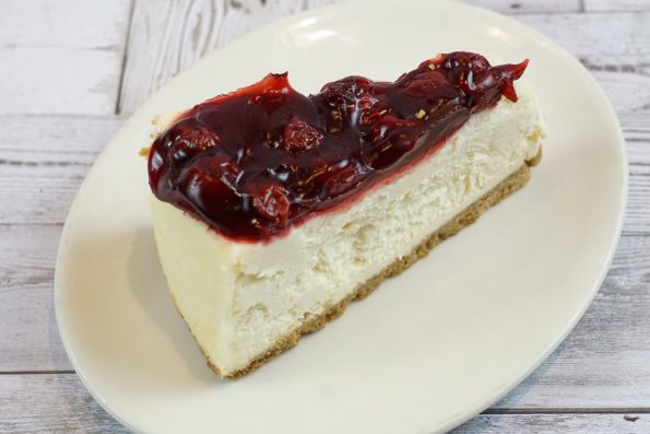 savor the classic flavor of a traditional New York style cherry cheesecake slice at Mia's Bakery.