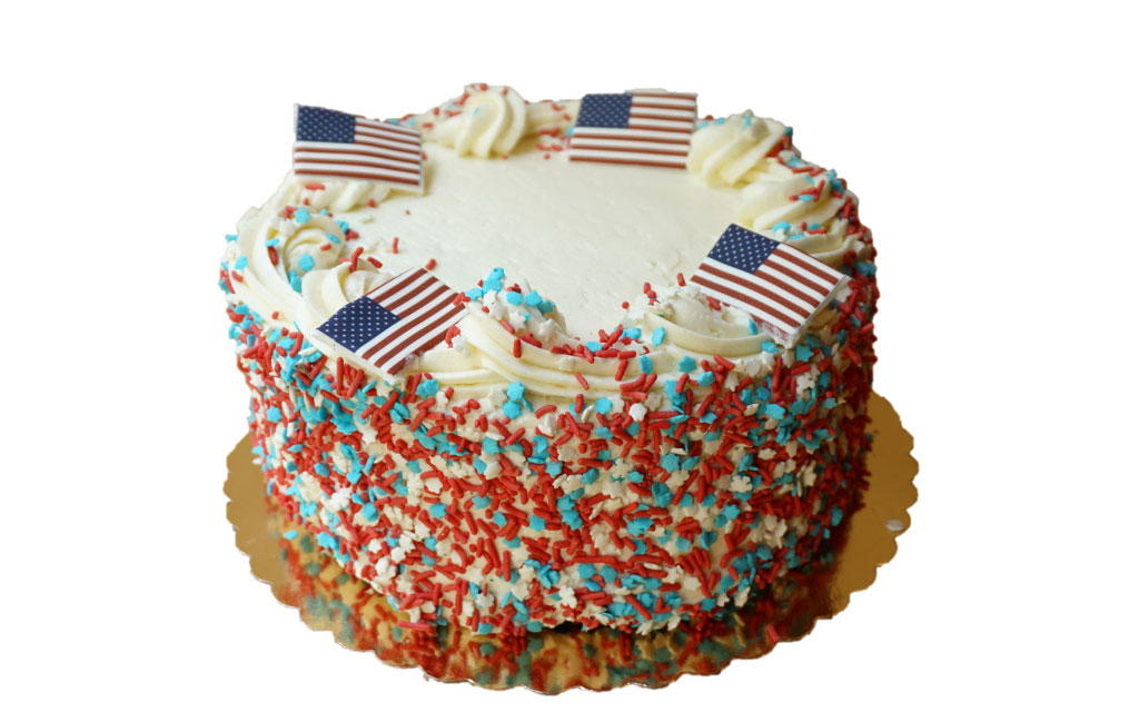 Red white and blue sprinkle cake with American flag toppers as festive 4th of July dessert ideas centerpiece