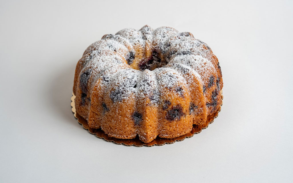 Spring dessert ideas blueberry bundt cake dusted with powdered sugar showing fresh berries throughout