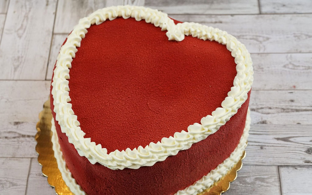 Heart shaped red velvet cake with white buttercream border piping, romantic valentines dessert ideas for couples and special celebrations