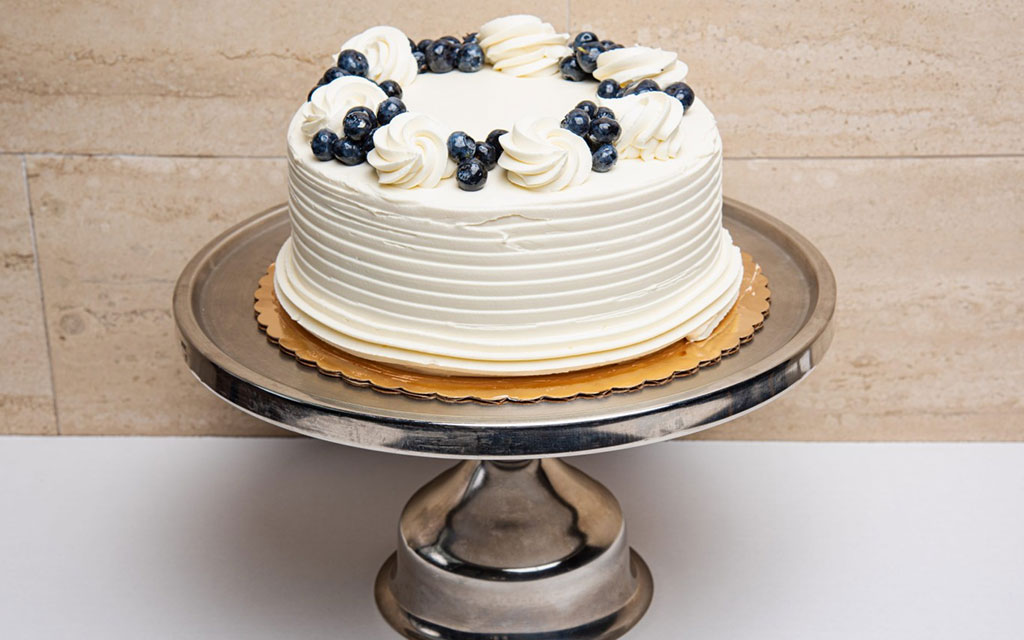 Spring dessert ideas featuring lemon blueberry layer cake with fresh blueberries and light whipped cream frosting