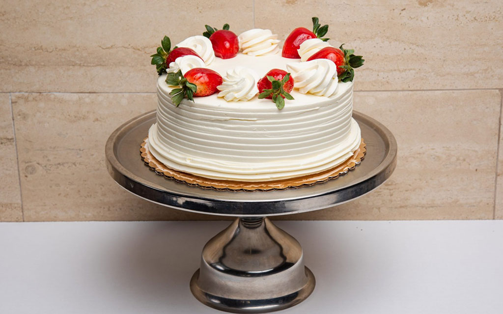 Spring dessert ideas featuring classic strawberry shortcake layer cake with fresh strawberries and whipped cream frosting
