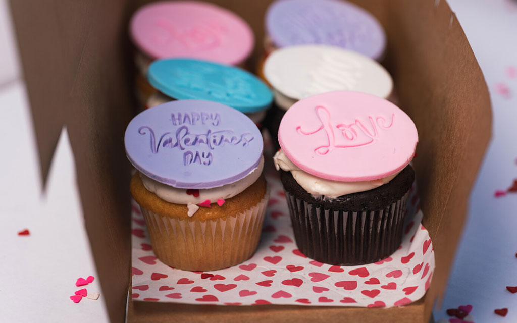 Assorted valentine's day cupcakes with pastel fondant toppers reading Happy Valentine's Day and Love, easy valentines dessert ideas for gifting