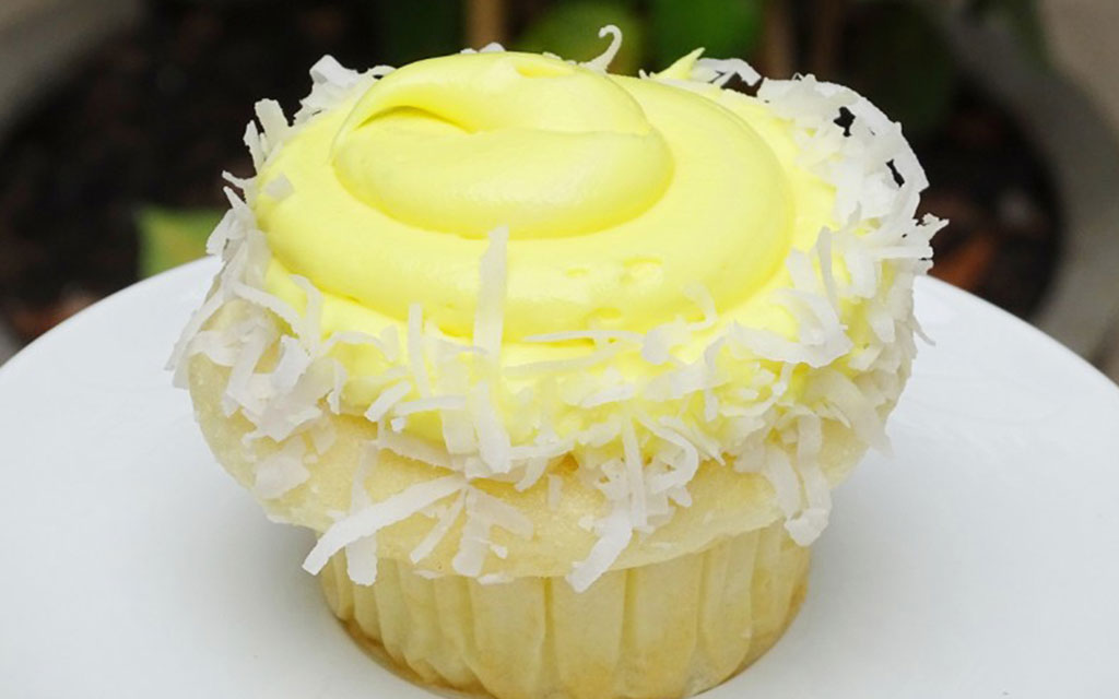 Best Easter desserts lemon cupcake topped with yellow frosting and shredded coconut