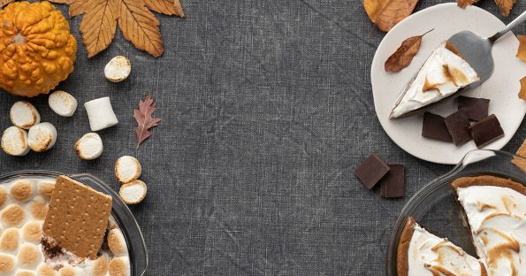 Assortment of fall desserts including pumpkin pie, apple crisp, and spiced cookies on rustic wooden table