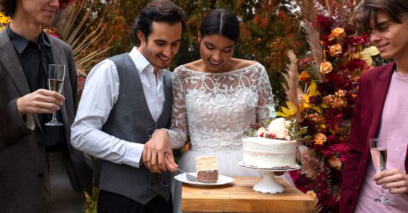 Elegant fall wedding cake with seasonal colors, autumn flowers, and warm venue lighting