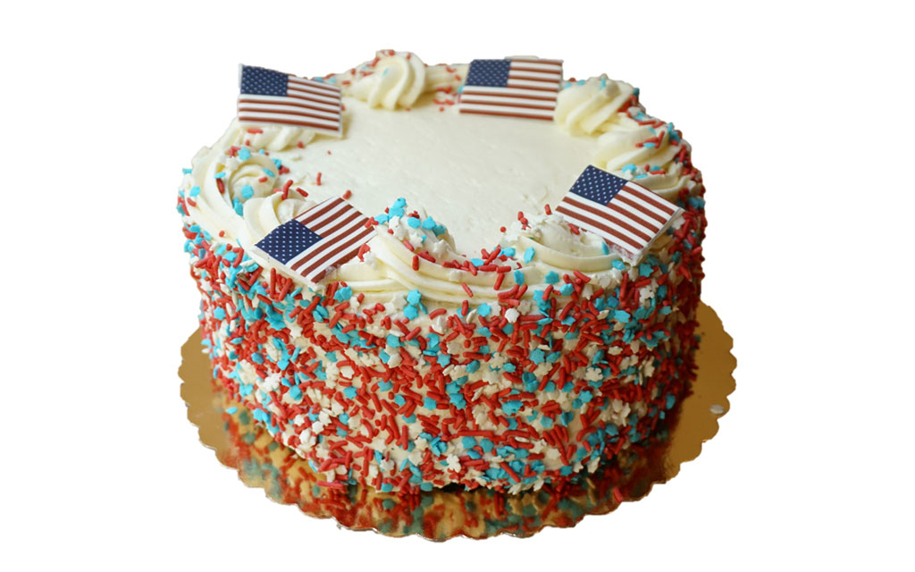 Seasonal desserts for Fourth of July with patriotic cake featuring red, white, and blue sprinkles and American flag toppers