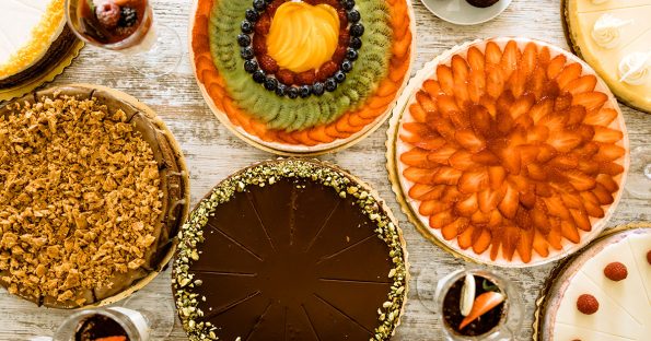 Seasonal desserts display featuring variety of cakes and tarts with fresh fruit toppings for year-round celebrations