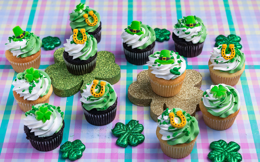 St Patrick's Day dessert ideas featuring green and white swirl cupcakes with shamrock, horseshoe and leprechaun hat toppers