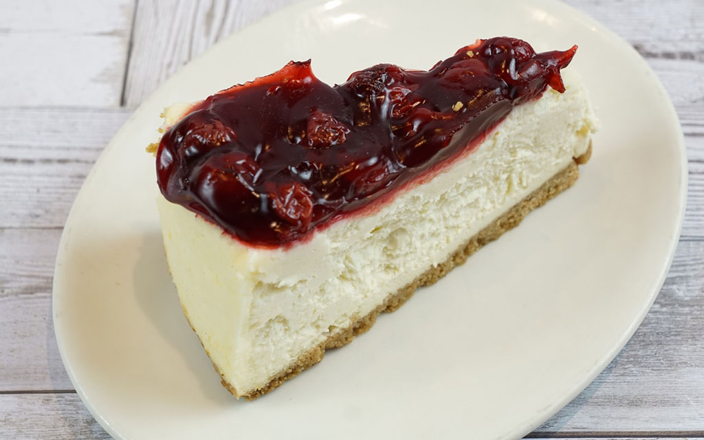 No-bake cherry cheesecake slice with graham cracker crust, a cool summer dessert idea for parties