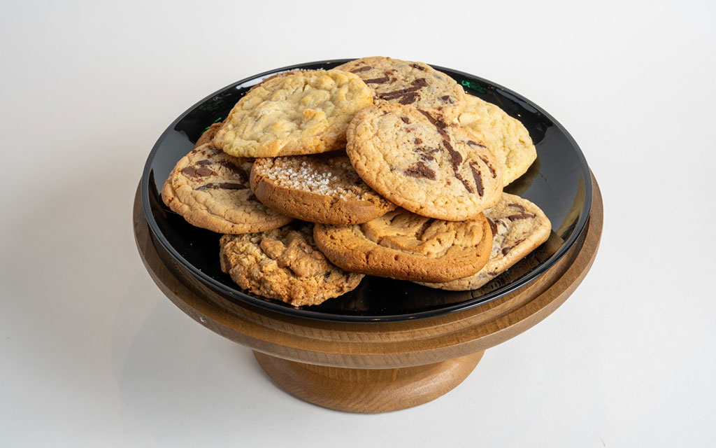 Stack of chocolate chip cookies with powdered sugar, a classic winter dessert idea for holiday cookie trays