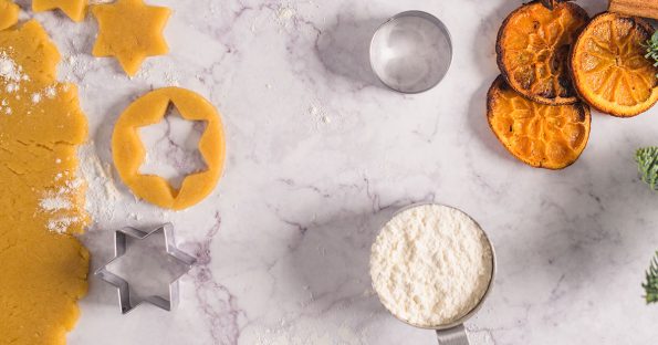 Holiday cookie dough with star cutters and dried oranges, representing festive winter dessert ideas and baking