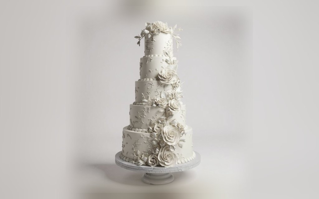Five-tier white wedding cake by Mia's Brooklyn Bakery with cascading sugar roses and bas-relief piping