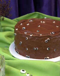Round chocolate Halloween cake in swirled chocolate frosting covered with candy eyeballs, Mia's Bakery