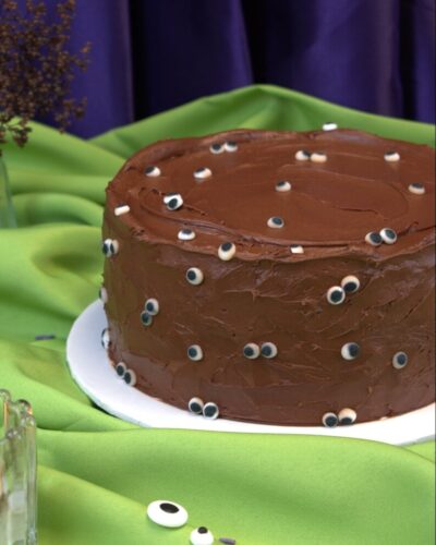 Round chocolate Halloween cake in swirled chocolate frosting covered with candy eyeballs, Mia's Bakery